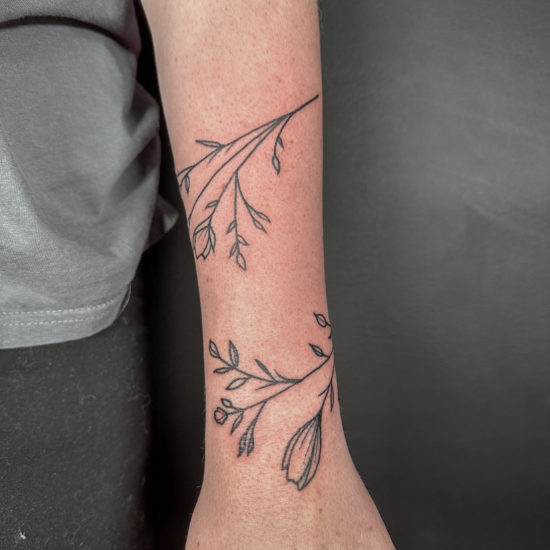 Picture of a wrapping vine arm tattoo.