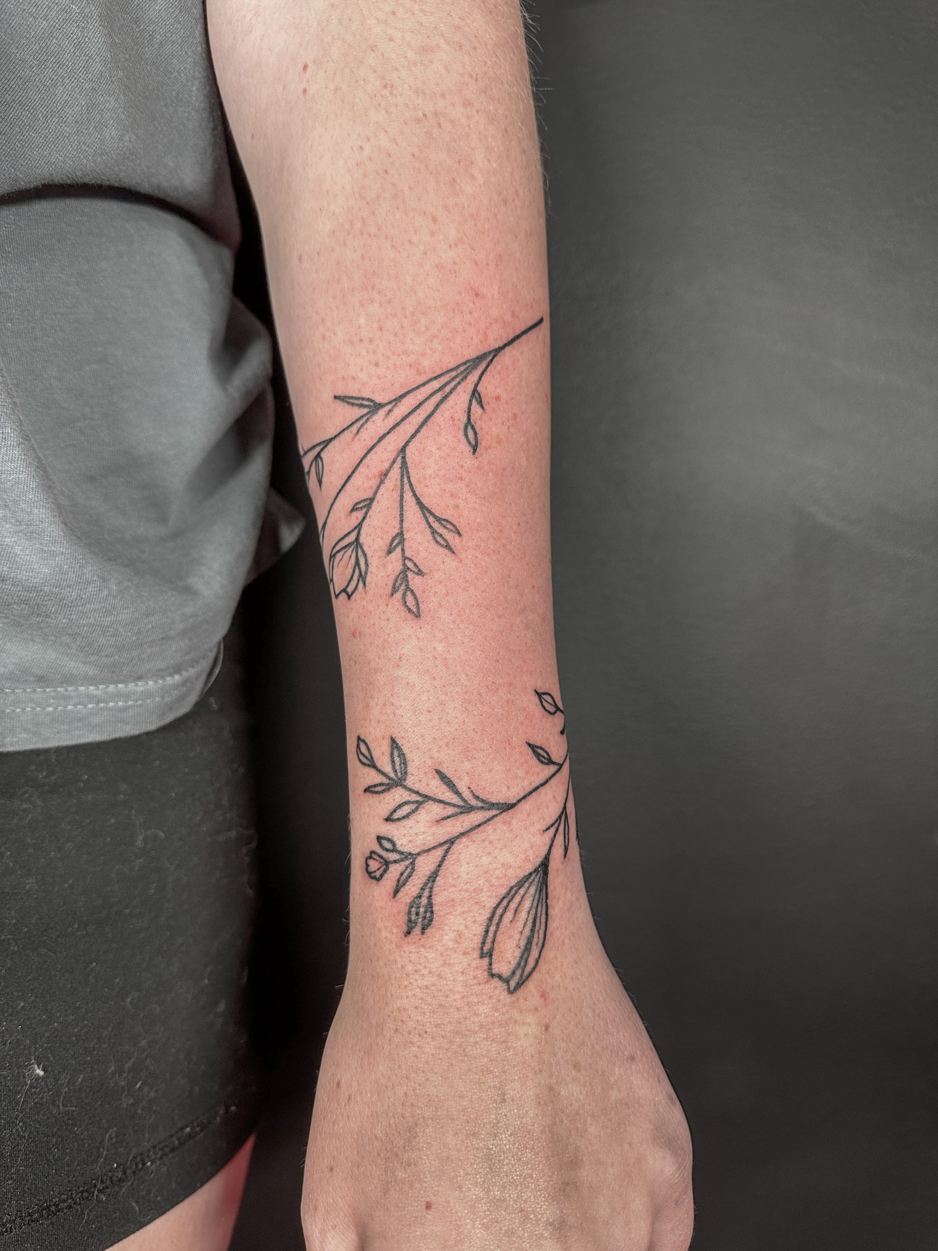 Picture of a wrapping vine arm tattoo.
