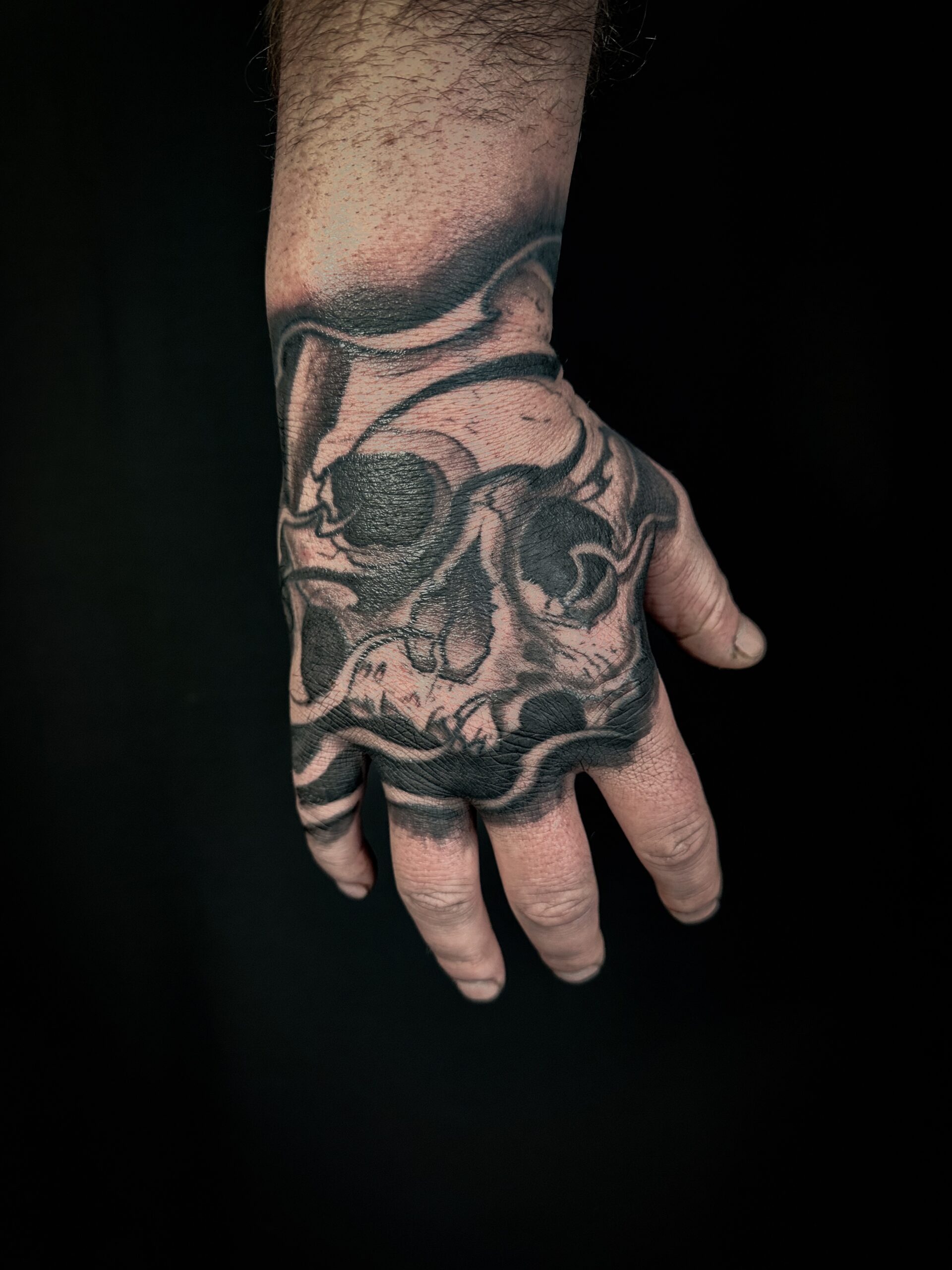 Hand blackwork skull tattoo